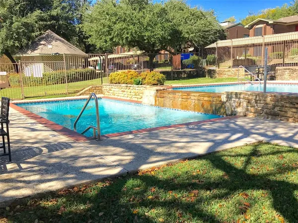 a view of a swimming pool with a lawn chairs and plants