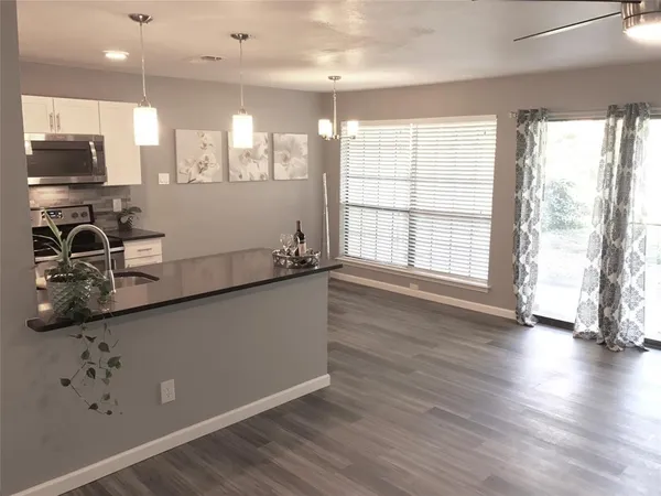 a kitchen with stainless steel appliances granite countertop a stove and a wooden floors