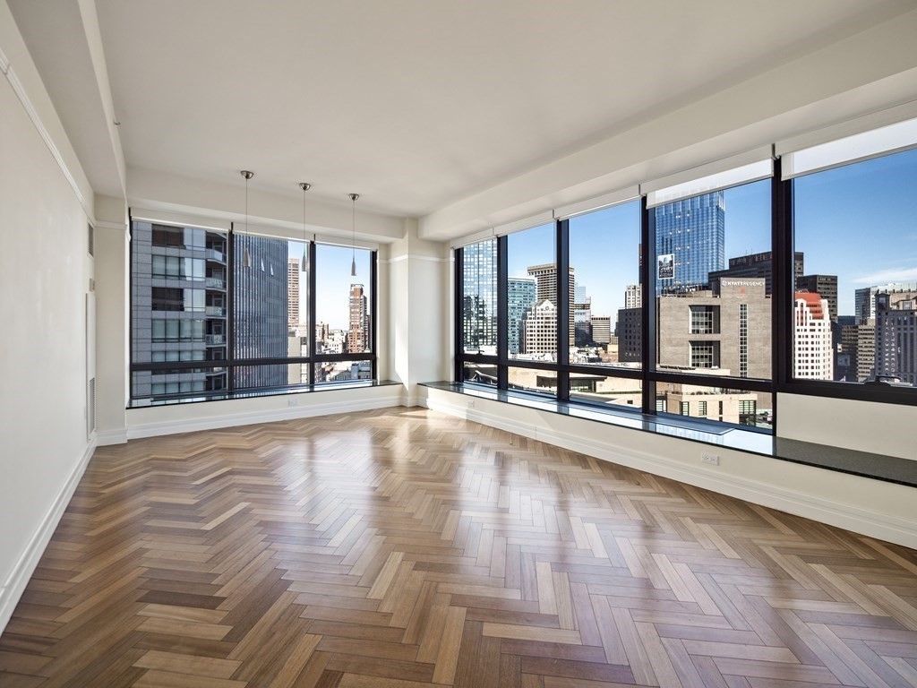 2 Avery Street, Unit 22G Boston, MA 02111 - Photo 2 of 28 a view of an empty room with window and wooden floor