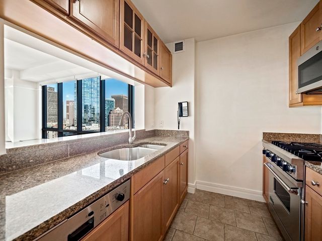 a kitchen with granite countertop a sink and a stove