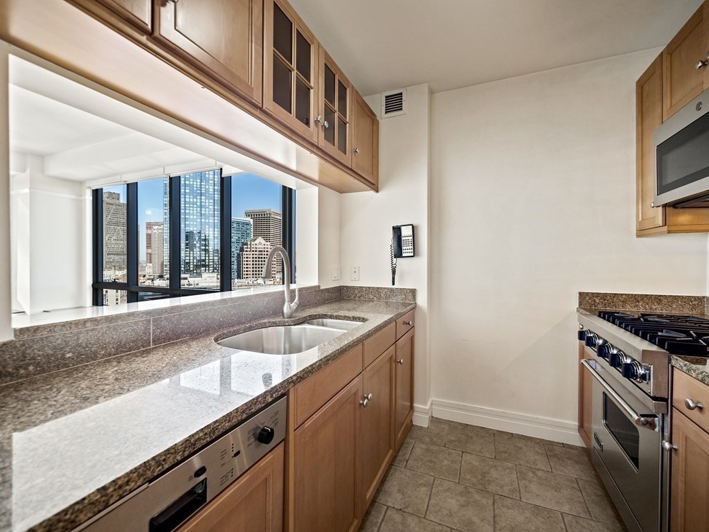 2 Avery Street, Unit 22G Boston, MA 02111 - Photo 8 of 28 a kitchen with granite countertop a sink and a stove
