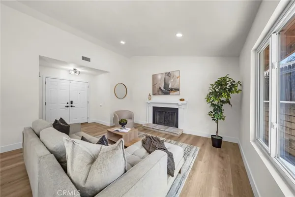 a living room with furniture a fireplace and a potted plant