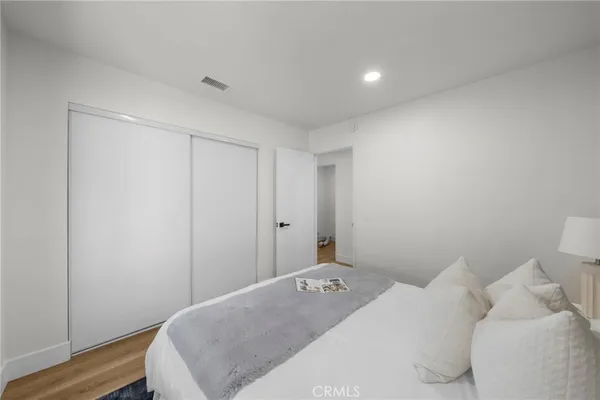 a bedroom with a bed and wooden floor