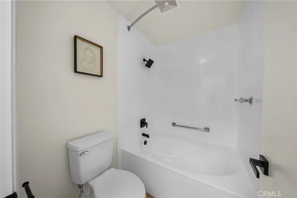 a white toilet sitting next to a bath tub