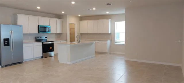 a kitchen with stainless steel appliances a refrigerator sink and microwave
