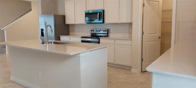 a kitchen with stainless steel appliances granite countertop a sink and a refrigerator