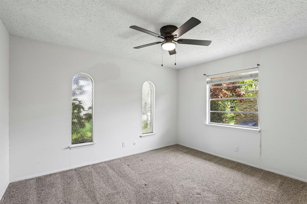 1600 South Timber Court Benbrook, TX 76126 - Photo 16 of 30 Carpeted interior space featuring a ceiling fan with light, one rectangular window, and two arched windows