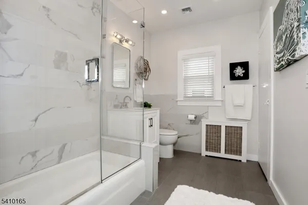 a bathroom with a granite countertop sink mirror and shower