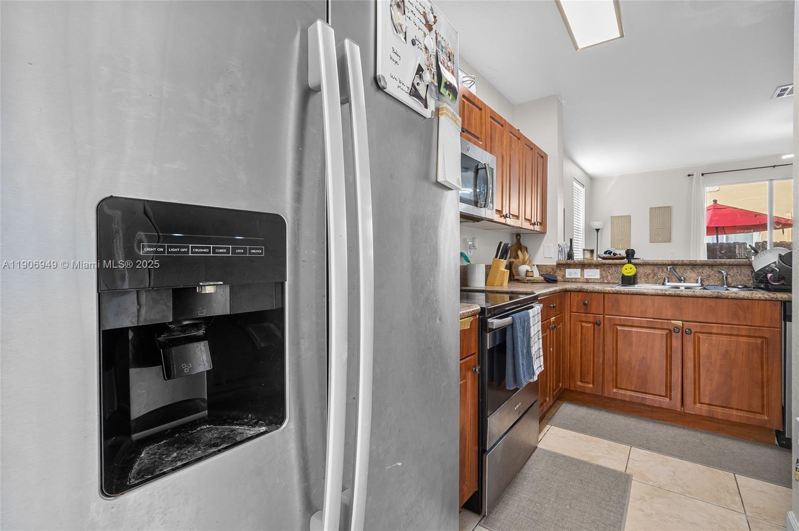 9239 Southwest 227th Street, Unit 1 Cutler Bay, FL 33190 - Photo 12 of 37 a kitchen with stainless steel appliances granite countertop a refrigerator and a stove top oven