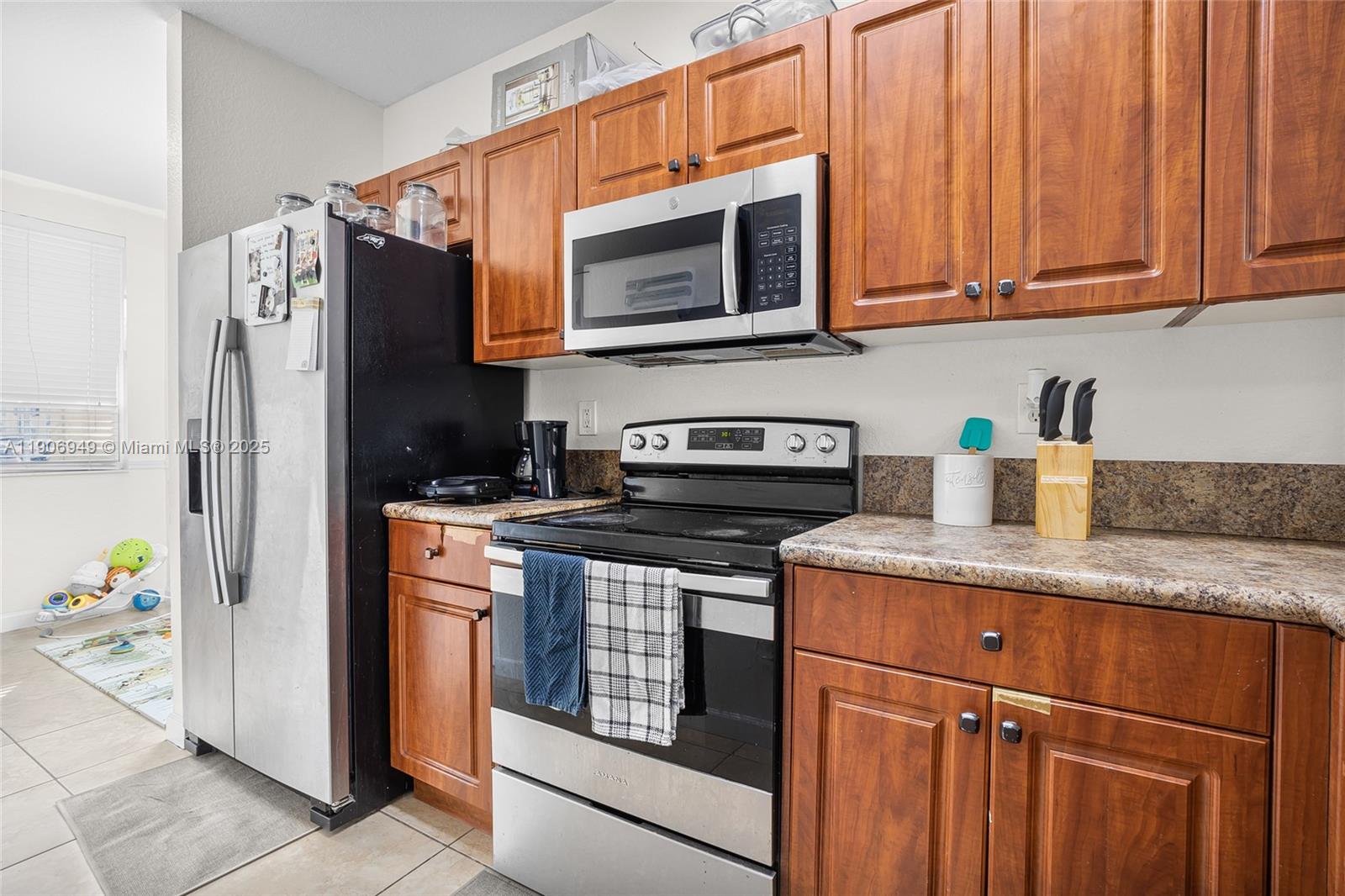 9239 Southwest 227th Street, Unit 1 Cutler Bay, FL 33190 - Photo 13 of 37 a kitchen with stainless steel appliances granite countertop a refrigerator stove and microwave