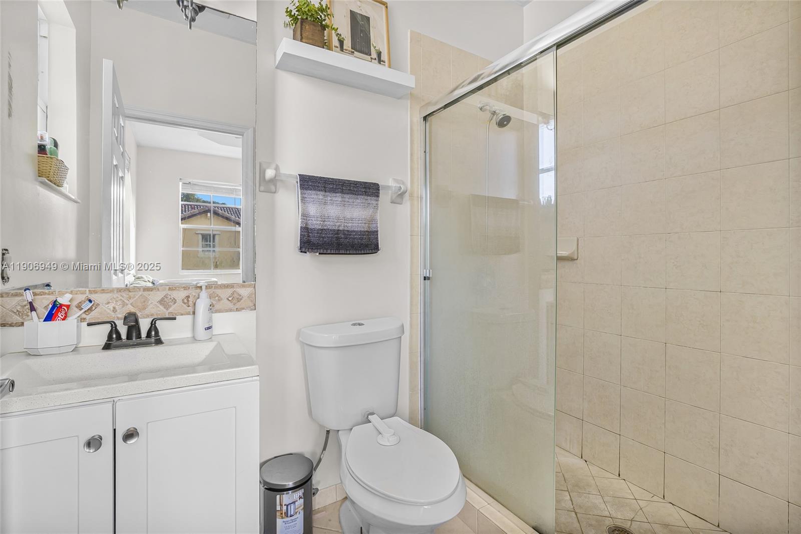 9239 Southwest 227th Street, Unit 1 Cutler Bay, FL 33190 - Photo 19 of 37 a bathroom with a toilet sink vanity and shower