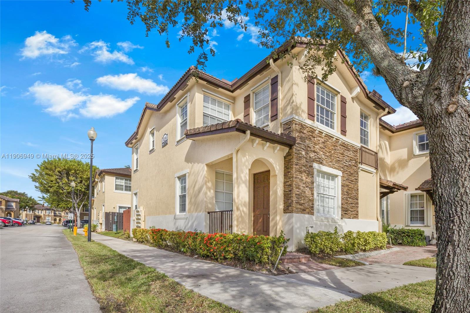 9239 Southwest 227th Street, Unit 1 Cutler Bay, FL 33190 - Photo 2 of 37 a view of a white building among the street with palm trees
