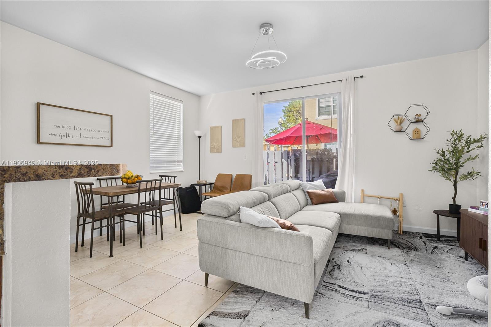9239 Southwest 227th Street, Unit 1 Cutler Bay, FL 33190 - Photo 8 of 37 a living room with furniture a chandelier and a dining table