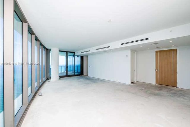 a large living room with stainless steel appliances kitchen island granite countertop furniture and a large window