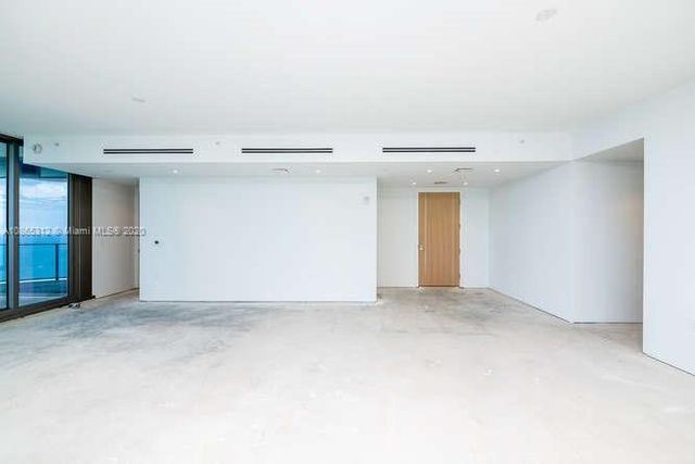 a view of a kitchen with furniture and stainless steel appliances
