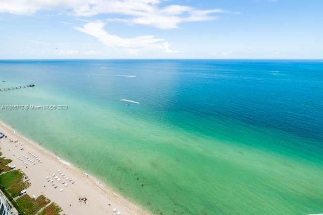 a bathroom with a granite countertop sink a toilet a mirror and shower