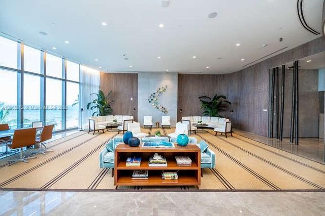 an empty room with furniture and large windows