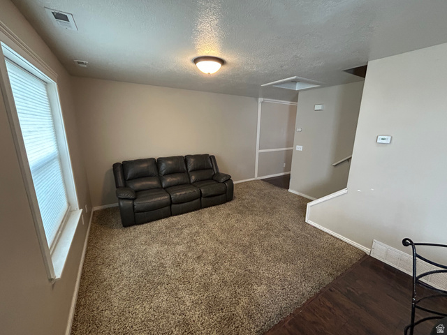 432 Spring Lane Logan, UT 84341 - Photo 6 of 22 Living room with a textured ceiling and dark colored carpet