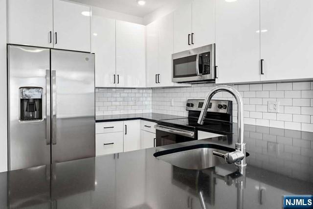 520 Cliff Street, Unit 215 Fairview, NJ 07022 - Photo 7 of 22 a kitchen with a refrigerator and a sink