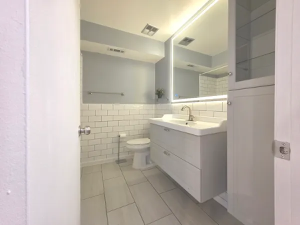 a bathroom with a sink toilet and mirror