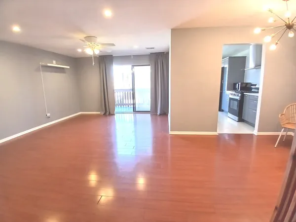 a view of a livingroom with wooden floor and a ceiling fan