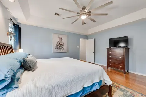 a bedroom with a bed and a flat tv screen on dresser
