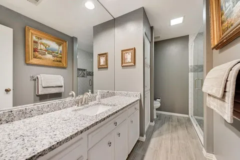 a bathroom with a granite countertop double vanity sink and a mirror
