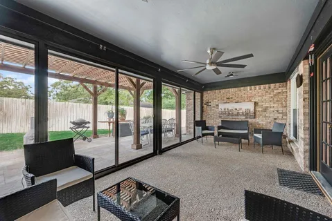 a living room with furniture a ceiling fan and a large window