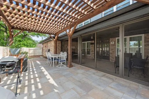 a view of a patio with table and chairs with wooden floor and fence