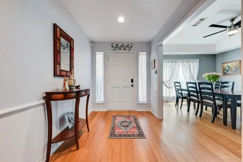 a view of a hallway with wooden floor and dining room