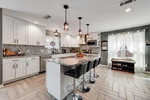 a kitchen with kitchen island granite countertop a sink appliances and cabinets