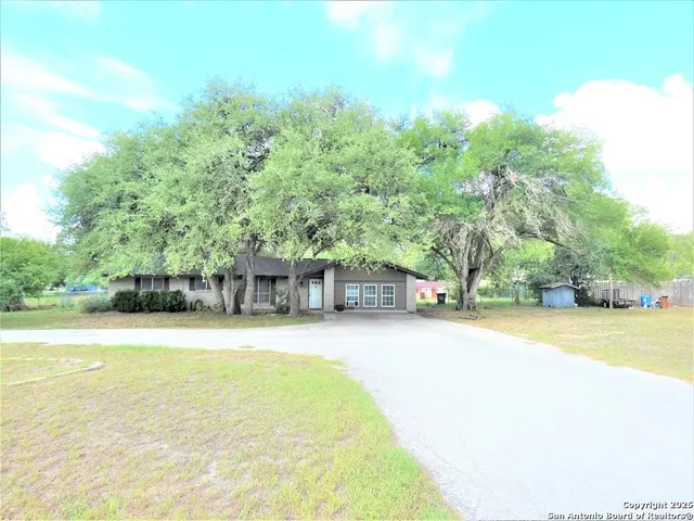 a front view of a house with a yard and trees