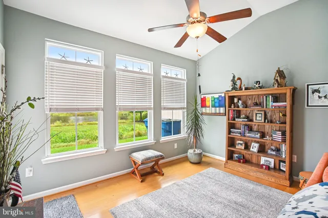 a living room with furniture a bookshelf and a window