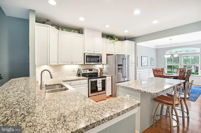 a dining room with wooden floor a chandelier a wooden table and chairs