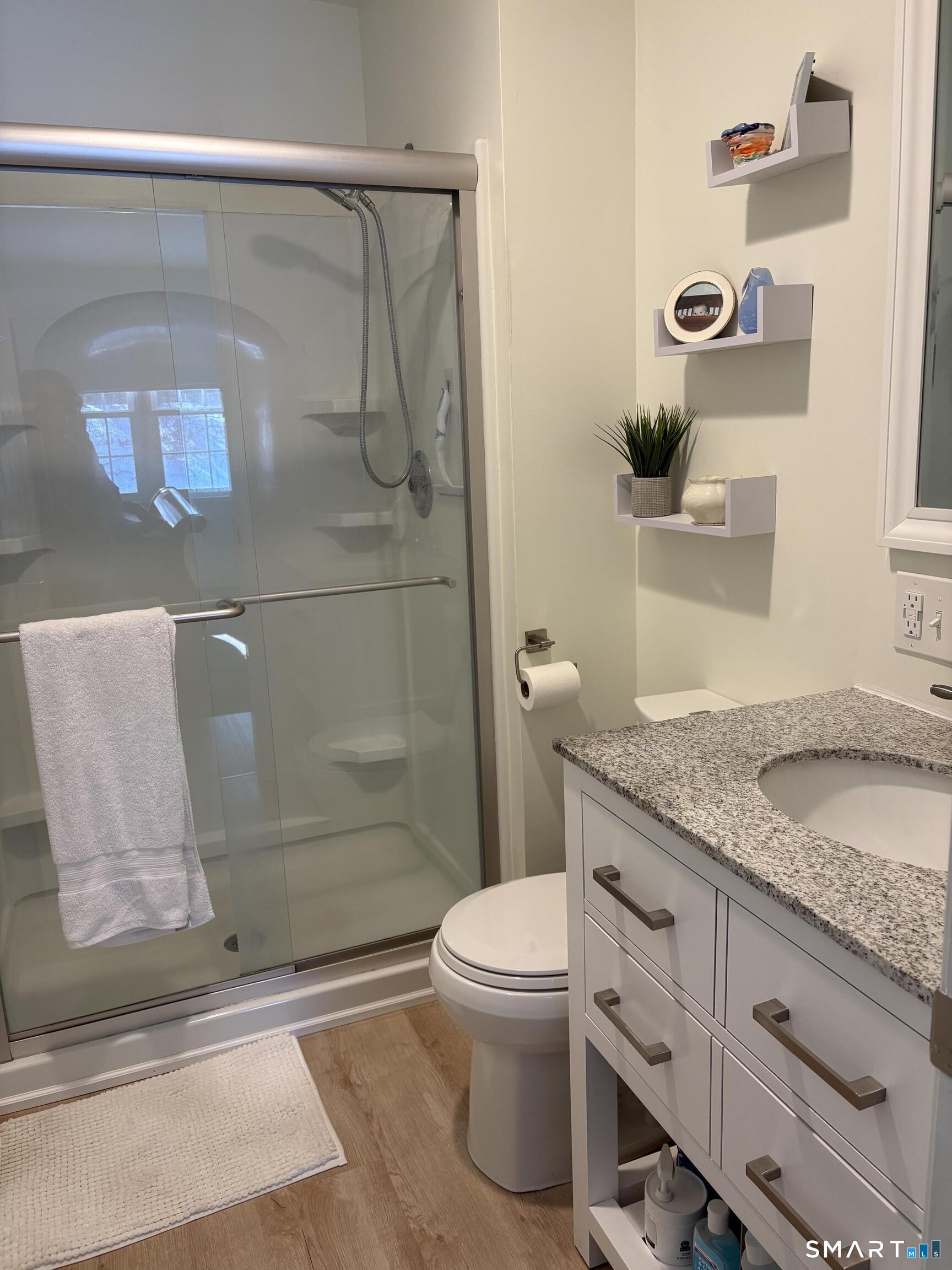 449 The Meadows Enfield, CT 06082 - Photo 8 of 11 a bathroom with a granite countertop sink a toilet and shower