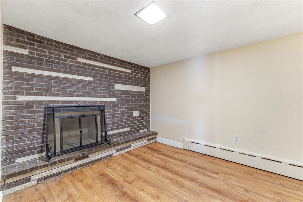 7 Carol Street Stoneham, MA 02180 - Photo 19 of 28 a view of empty room with wooden floor and fireplace