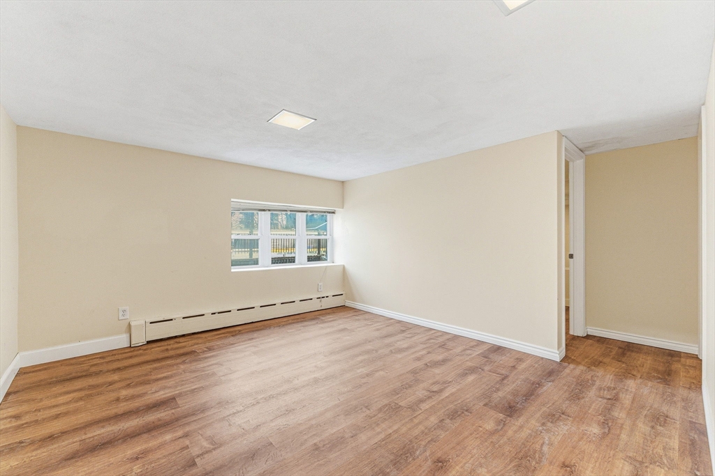 7 Carol Street Stoneham, MA 02180 - Photo 21 of 28 an empty room with wooden floor and windows