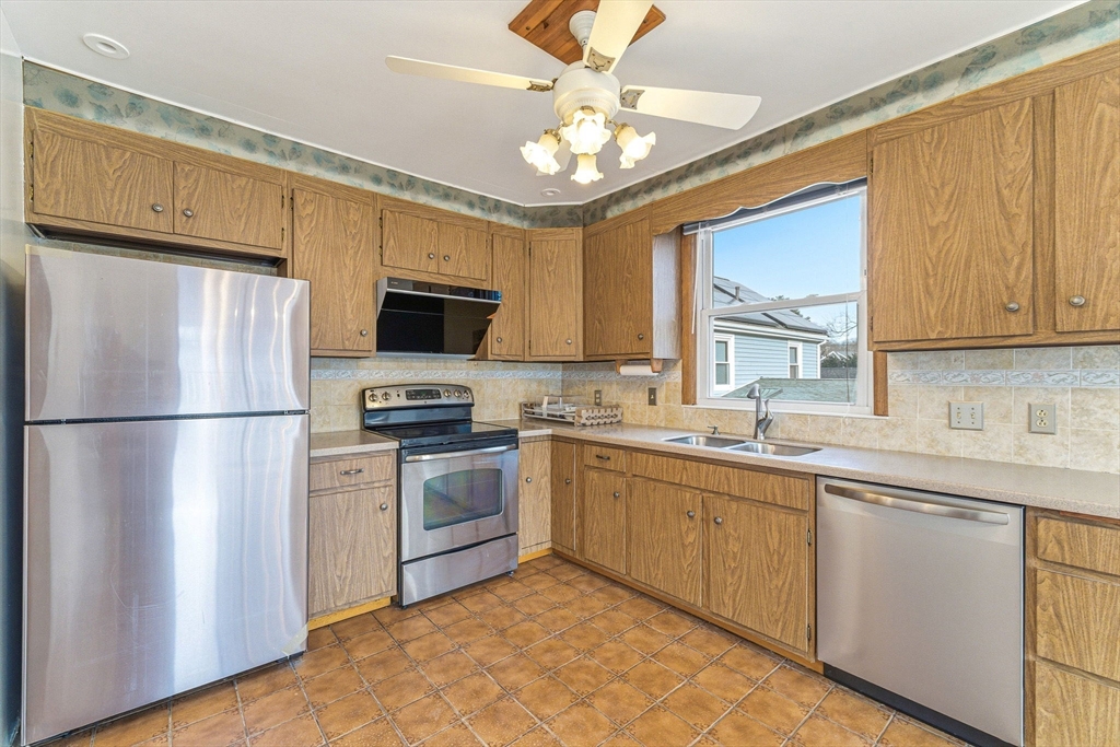 7 Carol Street Stoneham, MA 02180 - Photo 7 of 28 a kitchen with stainless steel appliances granite countertop a stove a sink dishwasher a refrigerator and a microwave oven with wooden floor
