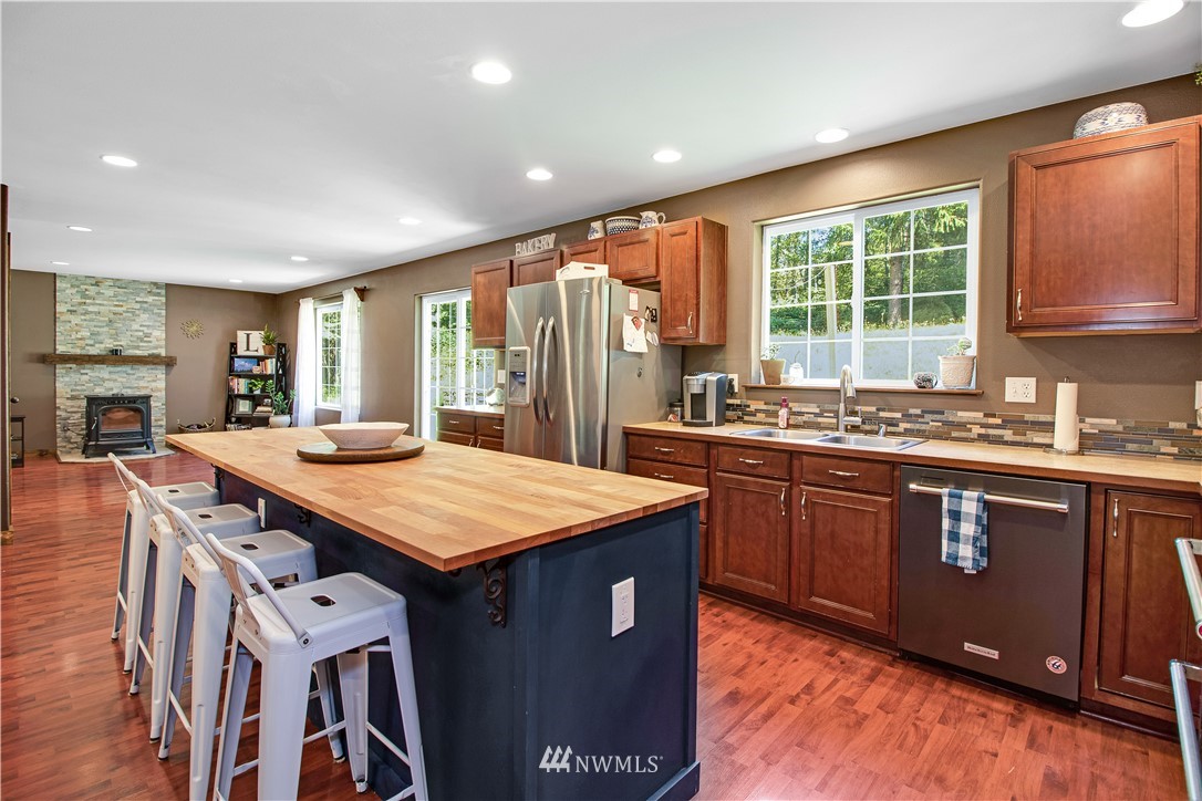 16704 Sargent Road Southwest Rochester, WA 98579 - Photo 12 of 40 a kitchen with a stove a sink a refrigerator and wooden cabinets