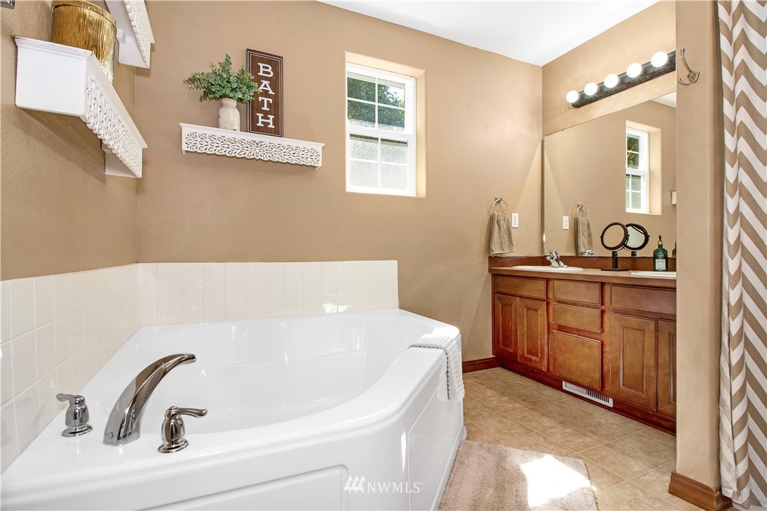 16704 Sargent Road Southwest Rochester, WA 98579 - Photo 23 of 40 a bathroom with a bathtub sink and mirror