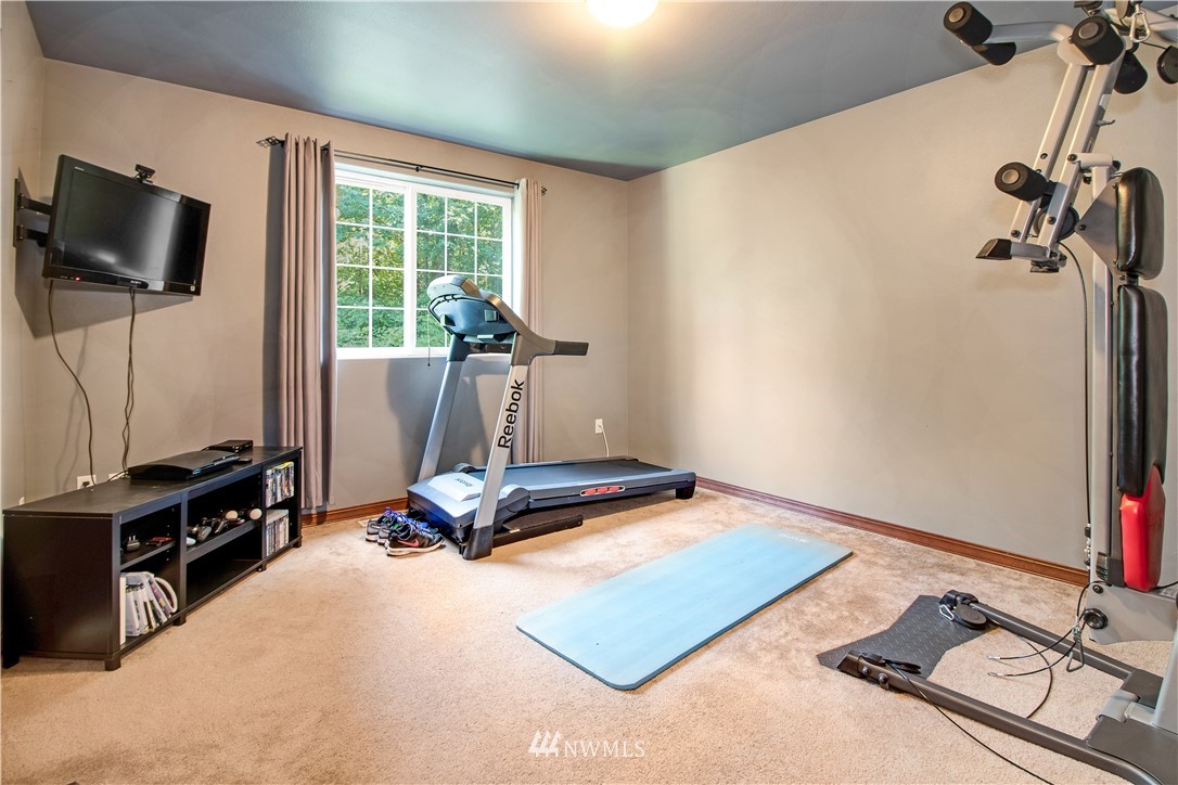 16704 Sargent Road Southwest Rochester, WA 98579 - Photo 29 of 40 a room with gym equipment and a flat screen tv