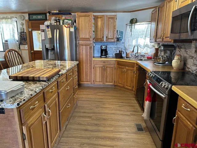 a kitchen with granite countertop a sink a counter top space and cabinets