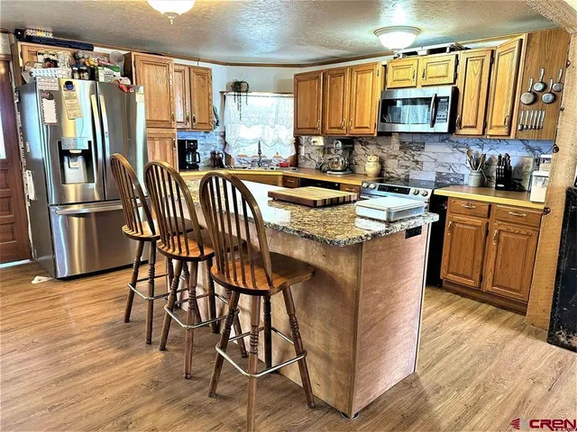 a kitchen with stainless steel appliances granite countertop a stove a sink dishwasher and a refrigerator