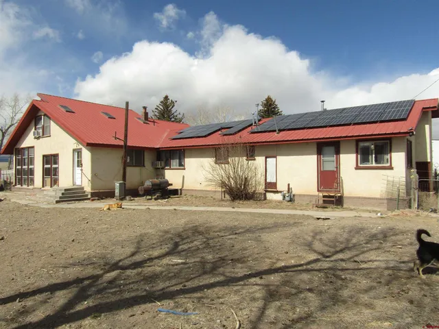 a view of a house with a patio and a yard