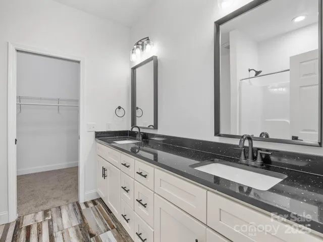 a bathroom with double sink and a mirror