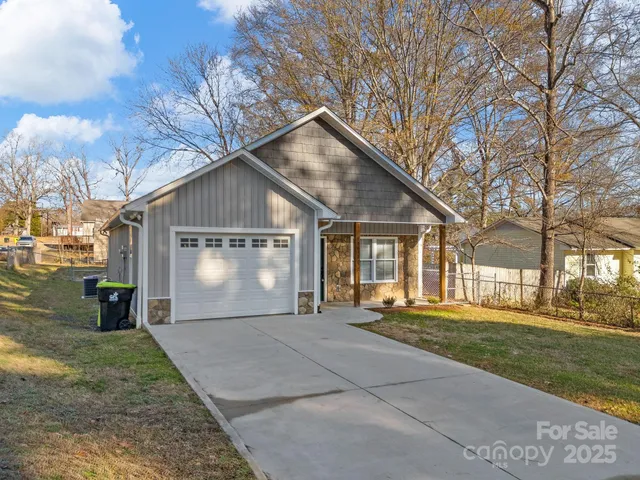 a front view of a house with a yard and trees