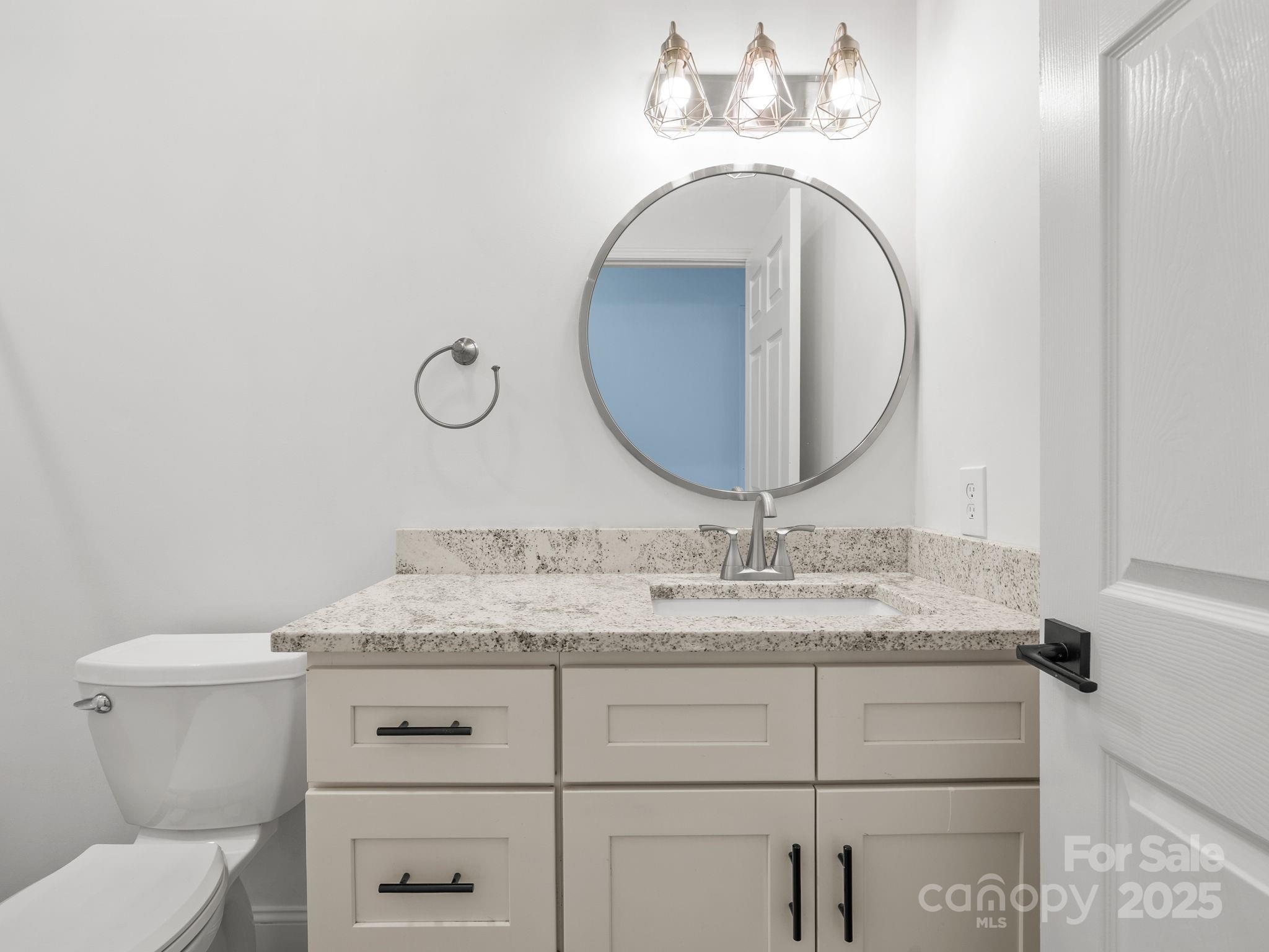 409 South Lyles Avenue Landrum, SC 29356 - Photo 26 of 36 a bathroom with a granite countertop toilet sink mirror and vanity