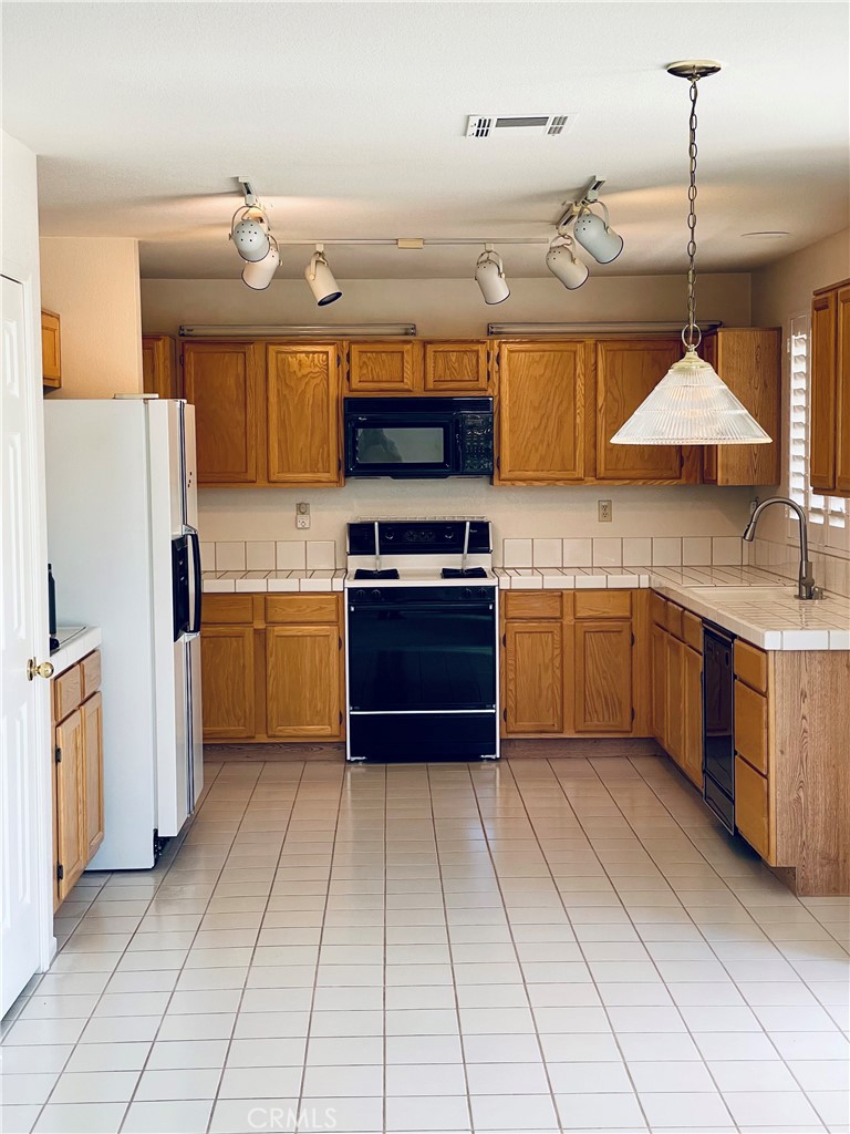 43222 Darby Street Lancaster, CA 93535 - Photo 2 of 9 a kitchen with stainless steel appliances granite countertop a sink counter space cabinets and a sink