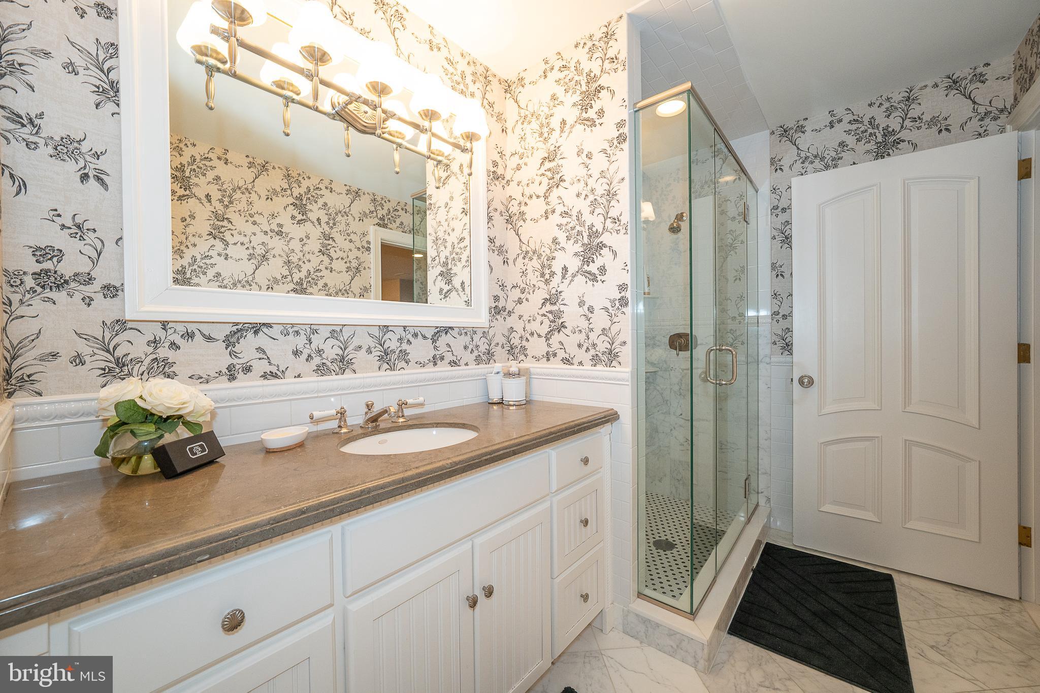 1122 Brynlawn Road Villanova, PA 19085 - Photo 34 of 46 a bathroom with a granite countertop sink a shower and a mirror