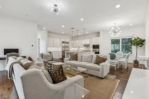 a living room with lots of white furniture and a chandelier